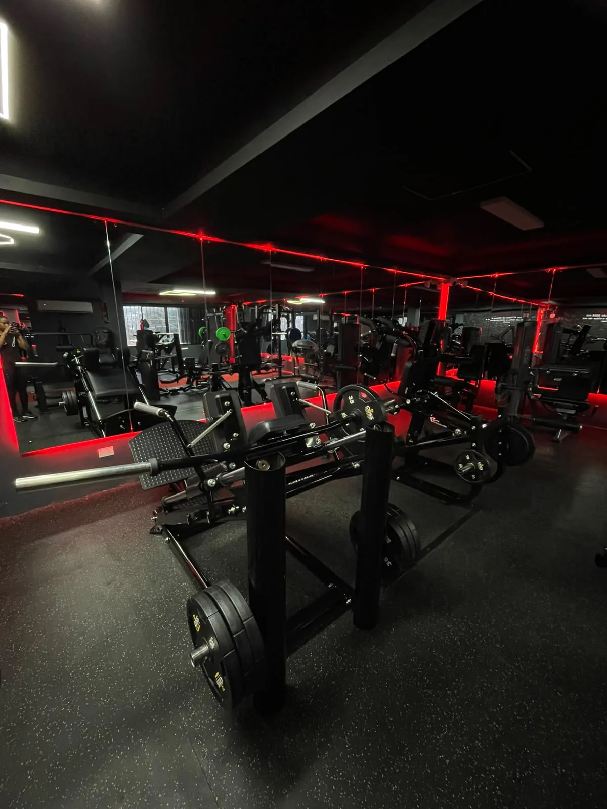 Sala de máquinas de Best Gym iluminada con luces LED rojas y espejos